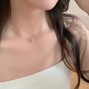 Macro detail of 14K gold plated four-leaf clover pendant necklace with sparkling zircons