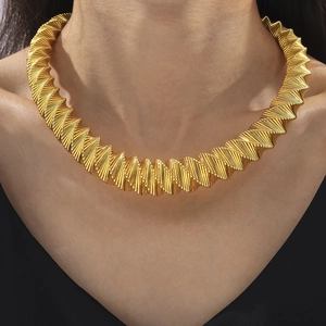 Golden geometric spring-shaped necklace with twisted link design worn by a model