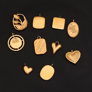 Detail showing ten gold heart and floral pendants on a black background