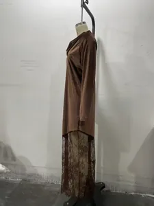 Détail d'une robe en velours montrant l'ourlet en dentelle élégant et la texture du tissu