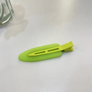Detail of bright green candy-colored hair clip with matte plastic and metal finish