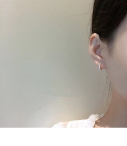Close-up of minimalist S925 silver gold-plated hoop earrings with small pearls on ear