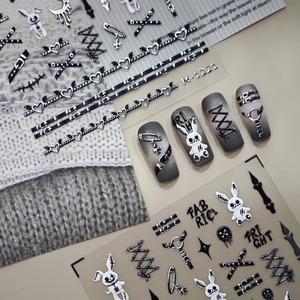 Gothic Halloween nail stickers with glowing skeletons and hearts on a sweater background