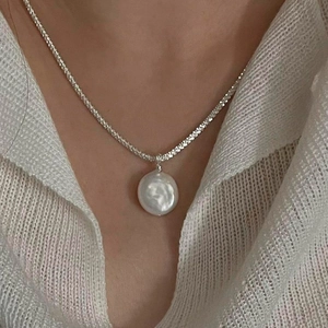 Elegant S925 sterling silver necklace featuring a shimmering baroque pearl pendant on a model