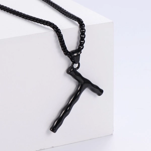 Vue rapprochée du pendentif lettre T noir sur bloc géométrique avec chaîne style minimaliste