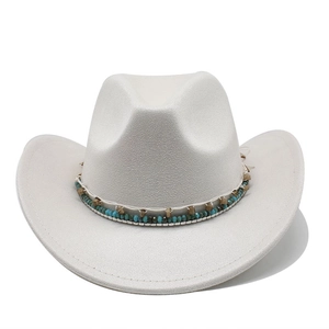 Détail d'un chapeau de cow-boy blanc avec un ruban ethnique orné de perles turquoise