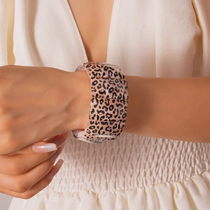 Detail of a wide elastic leopard print resin bracelet on model's wrist with pink tones