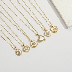 Close-up of gold-plated necklaces with heart, butterfly and shell pendants and crystals