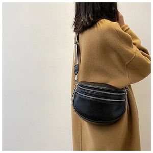 Detail of black lychee grain waist bag with three zippers and striped wide strap