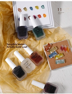 Artistic marble ink nail polish bottles in various colors on yellow textured paper