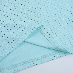 Close-up of light blue fabric with sparkling silver polka dots and neat stitching details