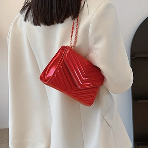 Fashionable red patent leather crossbody bag with chevron quilting and golden chain strap