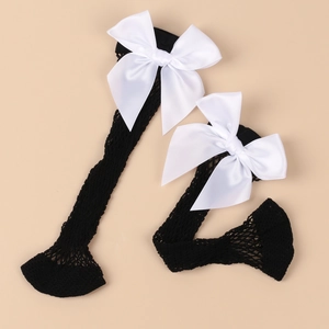 Detail of black mesh socks featuring large white satin bows against a beige background
