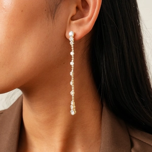 Close-up of elegant long tassel earrings with sparkling round zirconia and gold finish