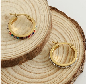 Close-up of 18K gold stainless steel hoop earrings with colorful and white crystals