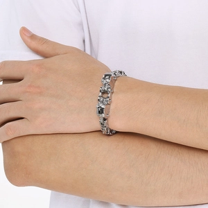 Détail d'un bracelet chaîne tête de mort en argent au poignet, bijou biker pour homme