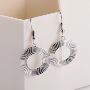Modern silver circular spiral earrings made of metal featuring a minimalist geometric design