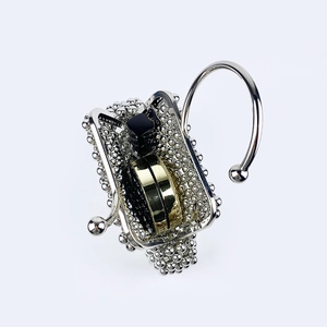 Close-up of decorative silver metal shower curtain hook with beaded edge and modern accents