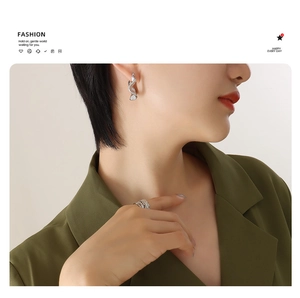 Detailed view of irregular fish-shaped earrings and ring set in polished silver finish