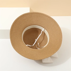 Detail of wide brim straw hat featuring internal sweatband and adjustable white tie string