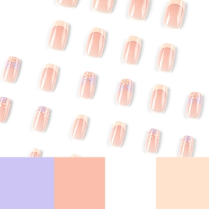 Short French tip press-on nails with yellow and purple floral patterns on white background