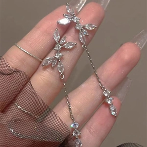 Close-up of elegant silver butterfly earrings with long tassels and sparkling crystals