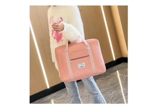 Pink waterproof travel bag showing front zipper pocket and durable webbed handles