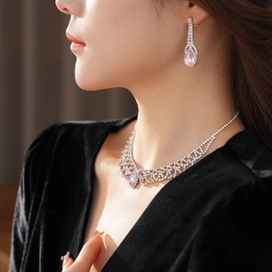 Detail of crystal pendant necklace and earrings with pink pear-shaped gemstones