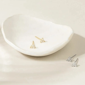 Détail de boucles d'oreilles minimalistes or et argent avec petits cristaux de zircon