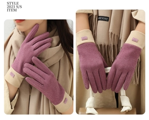 Detail of burgundy thermal gloves with fashion tag and stylish contrast stitching