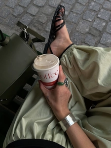 Street style shot of cotton balloon pants paired with a dark green leather bucket bag and sandals