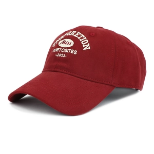 Detailed close-up of white letter embroidery on a burgundy cotton baseball cap