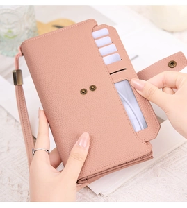 Detailed view of pink PU leather long wallet with wrist strap and internal card slots