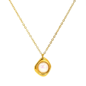 Gros plan d'un collier en titane doré avec un pendentif rond en perle au style lave