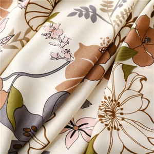 Macro detail of twill fabric showing tropical floral print and silky texture of the scarf
