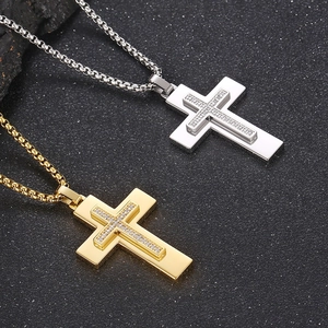 Close-up of double-layered cross pendants with cubic zirconia on stainless steel chains