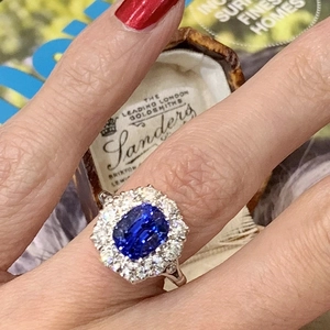 Elegante anillo de zafiro azul real y circón en la mano con montura floral de plata vieja