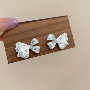 Elegante silberne Schleifen-Ohrstecker mit Kristallen für einen schicken Minimalismus