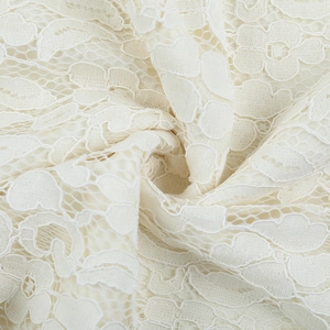Close-up of elegant creamy white lace fabric with intricate floral hollow-out textures