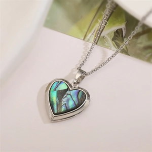 Detailed view of silver heart locket necklace with iridescent natural abalone shell inlay