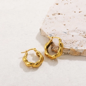 Detail view of gold croissant hoop earrings with a twisted rope design and polished finish