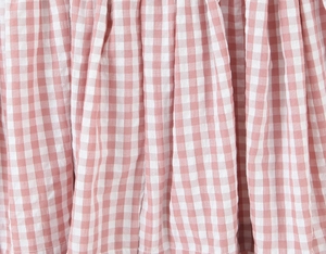 Détail du tissu à carreaux vichy rose et blanc avec dentelle et plis texturés