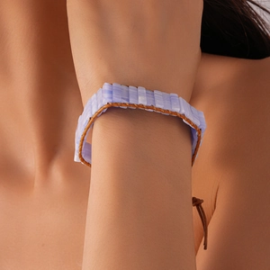 Close-up of bohemian blue lace agate stone bracelet with brown leather braided cord