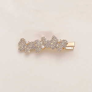 Dettaglio di un fermaglio per capelli a farfalla dorato con strass e perle eleganti