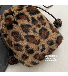 Macro view of leopard print plush bag with leather drawstring and woven knot detail