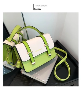 Detail view of the green and cream contrast leather handbag with decorative straps