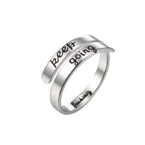 Detail view of silver stainless steel ring with black etched Keep Going inscription