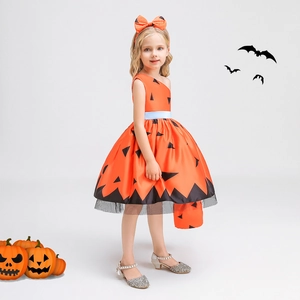 Detail of orange pumpkin themed girls dress with black patterns and bow headband