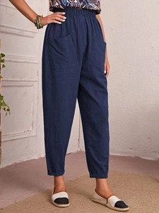 Detail of dark blue linen harem pants featuring elastic high waist and large side pockets