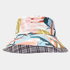 Detail of reversible sun hat showing tropical leaf print and black white plaid lining